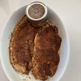 Two steaks in a dish with BBQ seaweed rub on them 